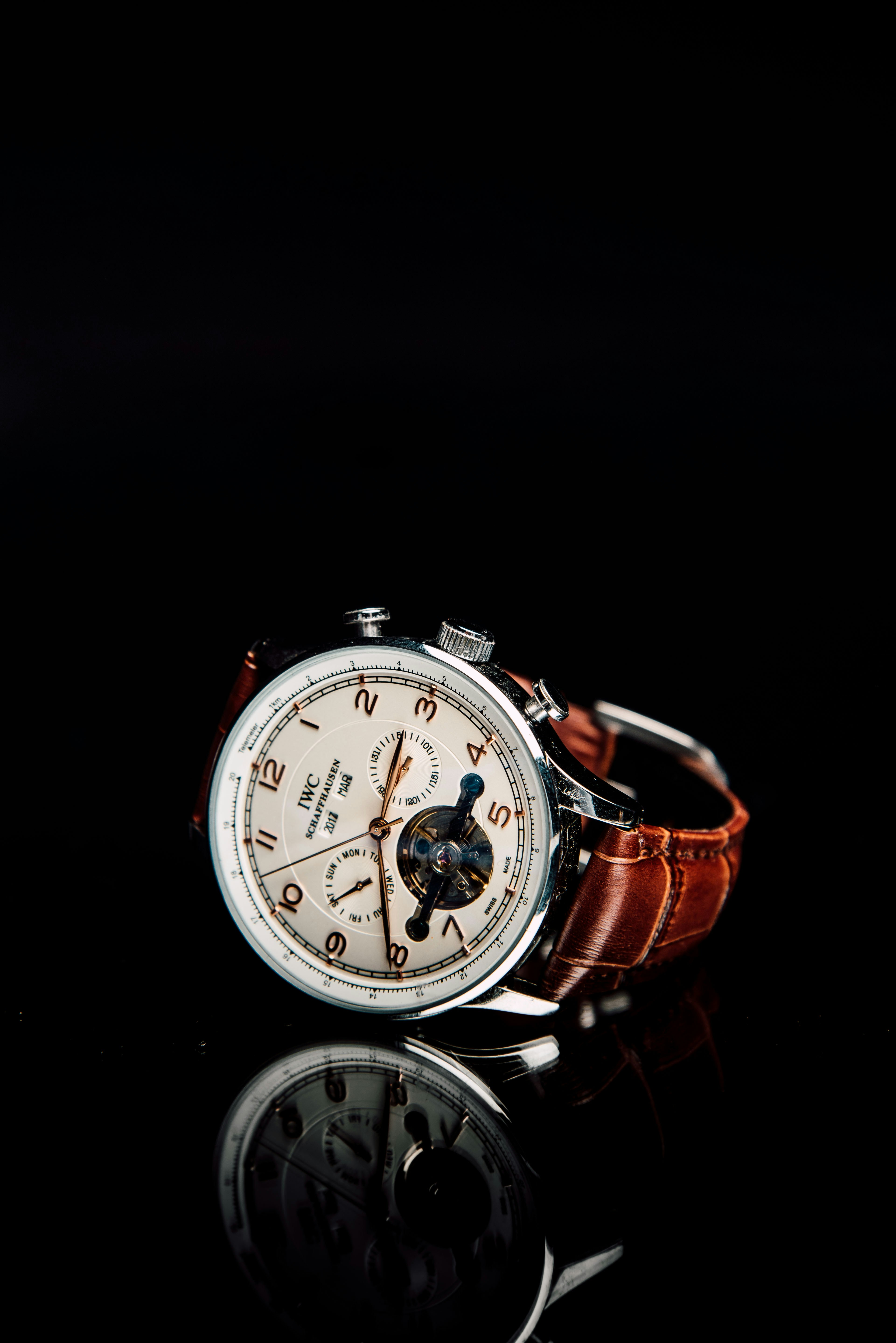 IWC pilot's watch on dark leather surface, showing case and crown detail